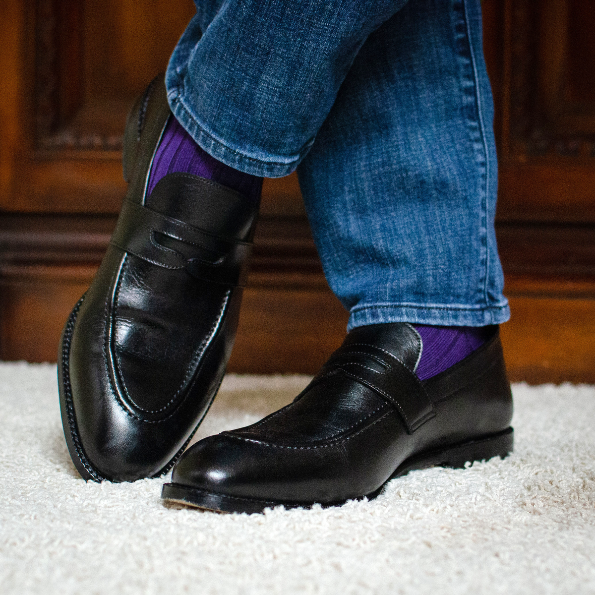 man standing crossing his legs at the ankles wearing jeans, black loafers, and Purple Cotton Mid Calf Dress Socks