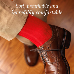 man crossing leg wearing khakis with bright red dress socks and dark brown wingtips