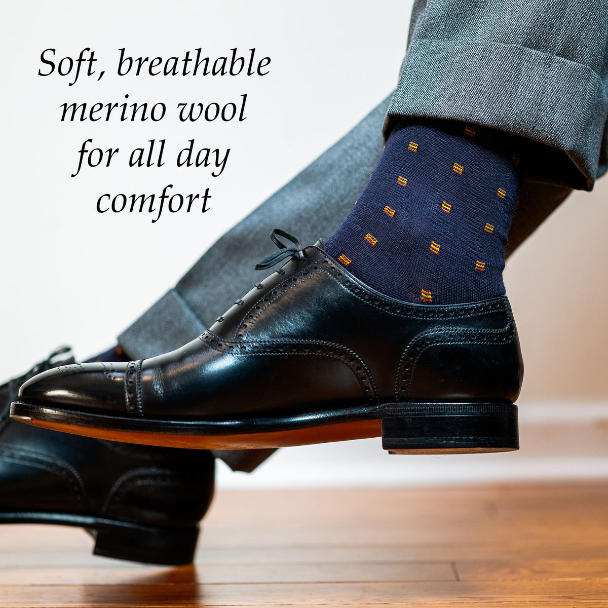 man wearing navy and orange patterned dress socks with black oxfords and grey slacks