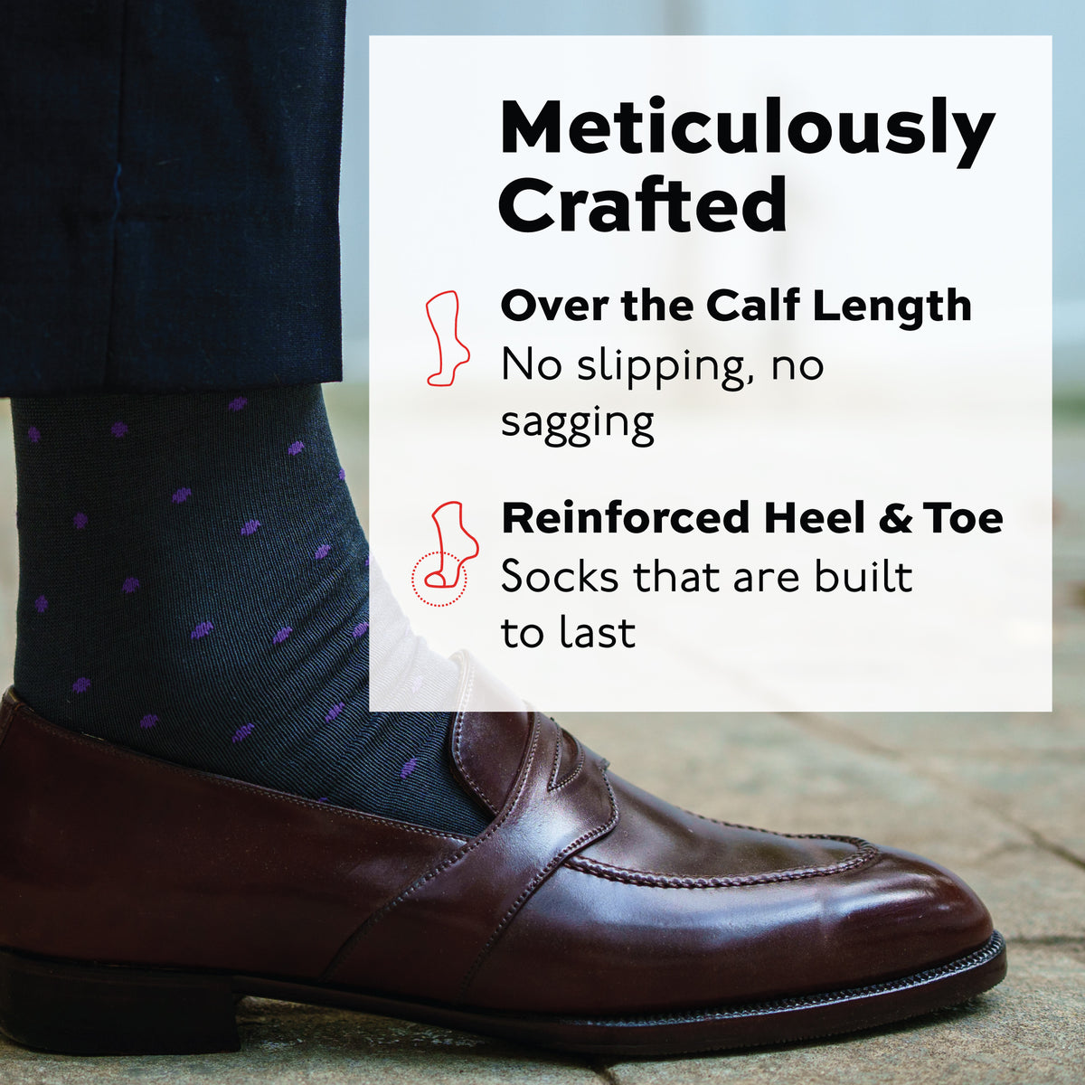 persons right foot standing on the ground in a loafer and purple dots on grey cotton dress socks