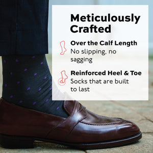 persons right foot standing on the ground in a loafer and purple dots on grey cotton dress socks