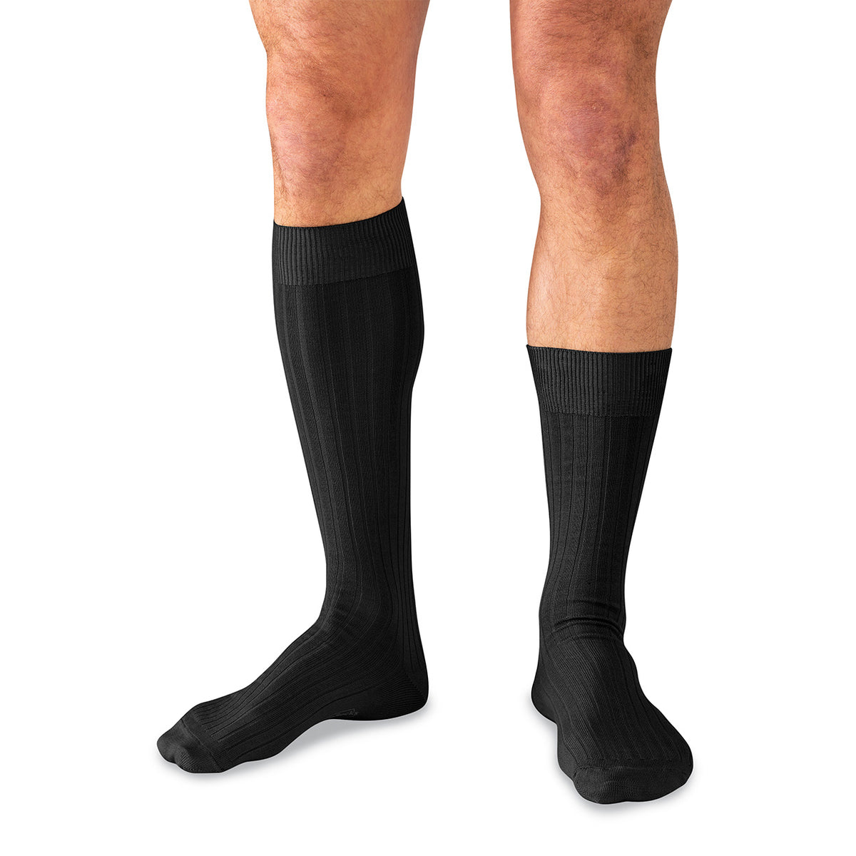 man wearing black over the calf dress sock on one leg and black mid-calf dress sock on the other leg