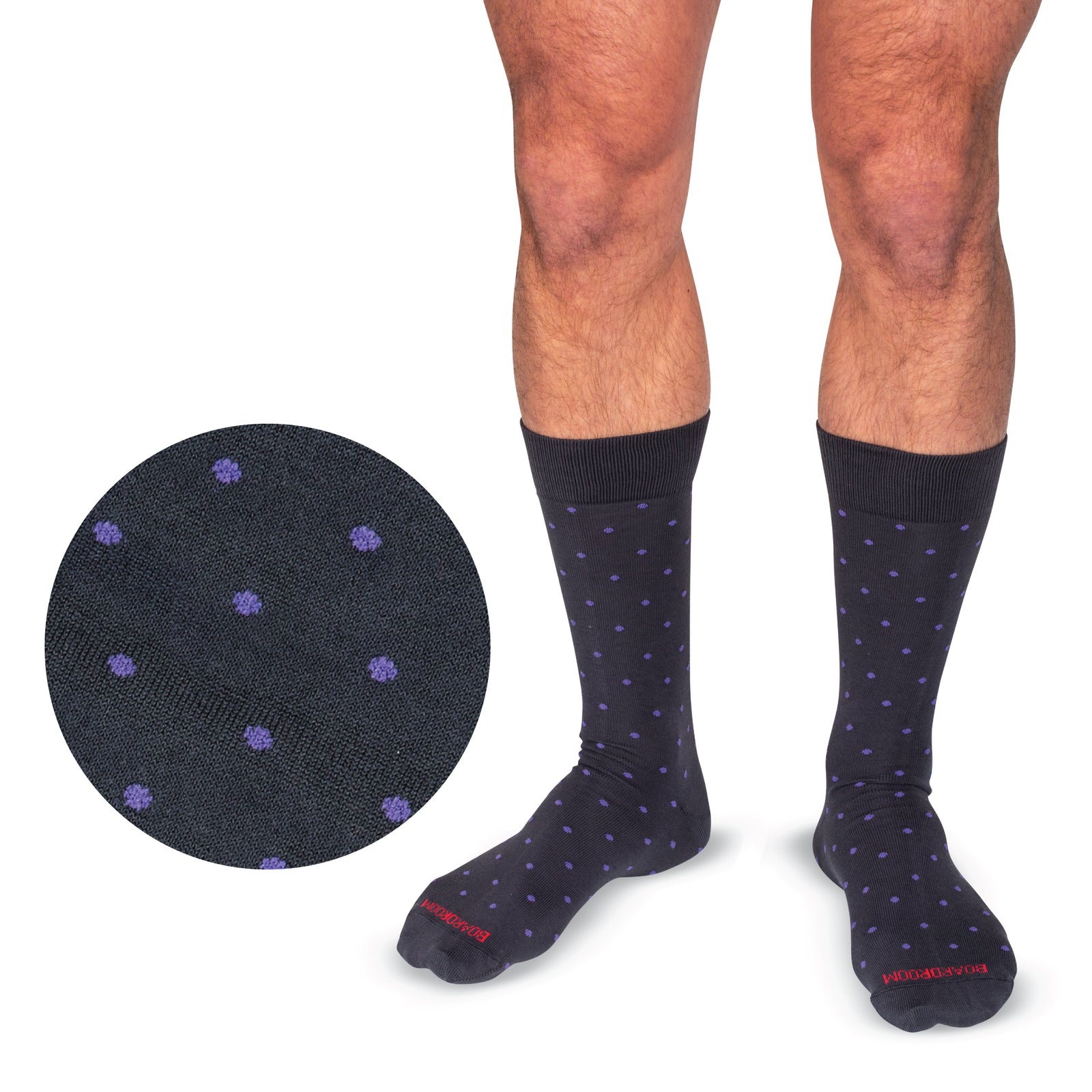 model wearing mid-calf length grey cotton dress socks with purple polka dots standing with a white background
