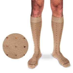 model wearing khaki over the calf cotton dress socks with a geometric pattern on a white background