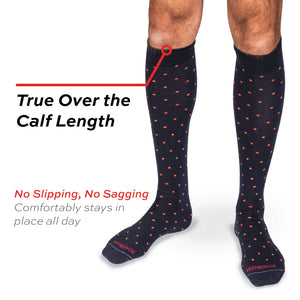 model standing wearing navy with orange dot over the calf length merino wool dress socks with no slipping, no sagging text overlay