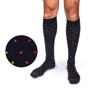 model's legs on a white background wearing over the calf merino wool navy socks with a tri-color dot pattern