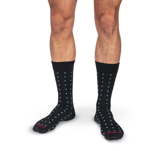 model wearing black cotton dress socks with geometric blue patterns