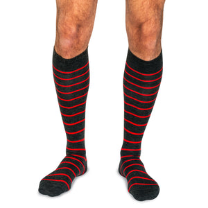 model wearing charcoal grey and red striped over the calf dress socks