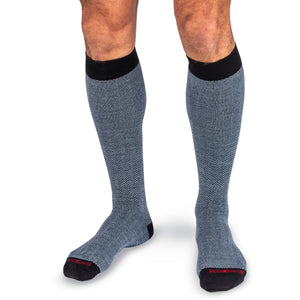 model wearing over the calf length light blue and black herringbone dress socks