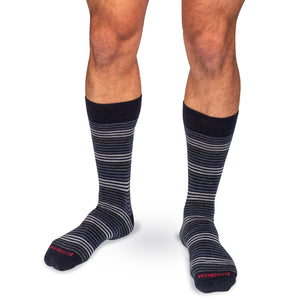model wearing navy and grey horizontal striped dress socks on white background