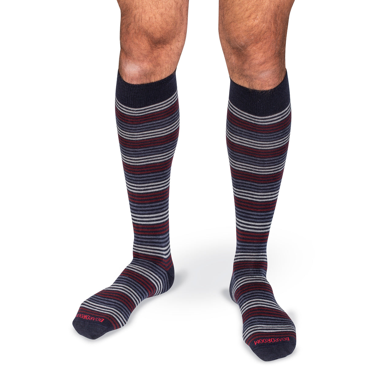 Knee-high striped dress socks worn by a model on a white background