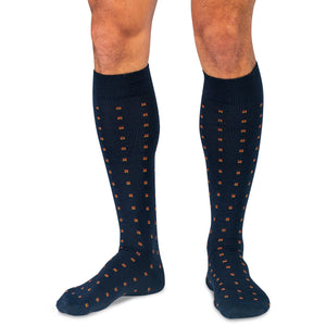 model wearing orange and navy patterned over the calf dress socks