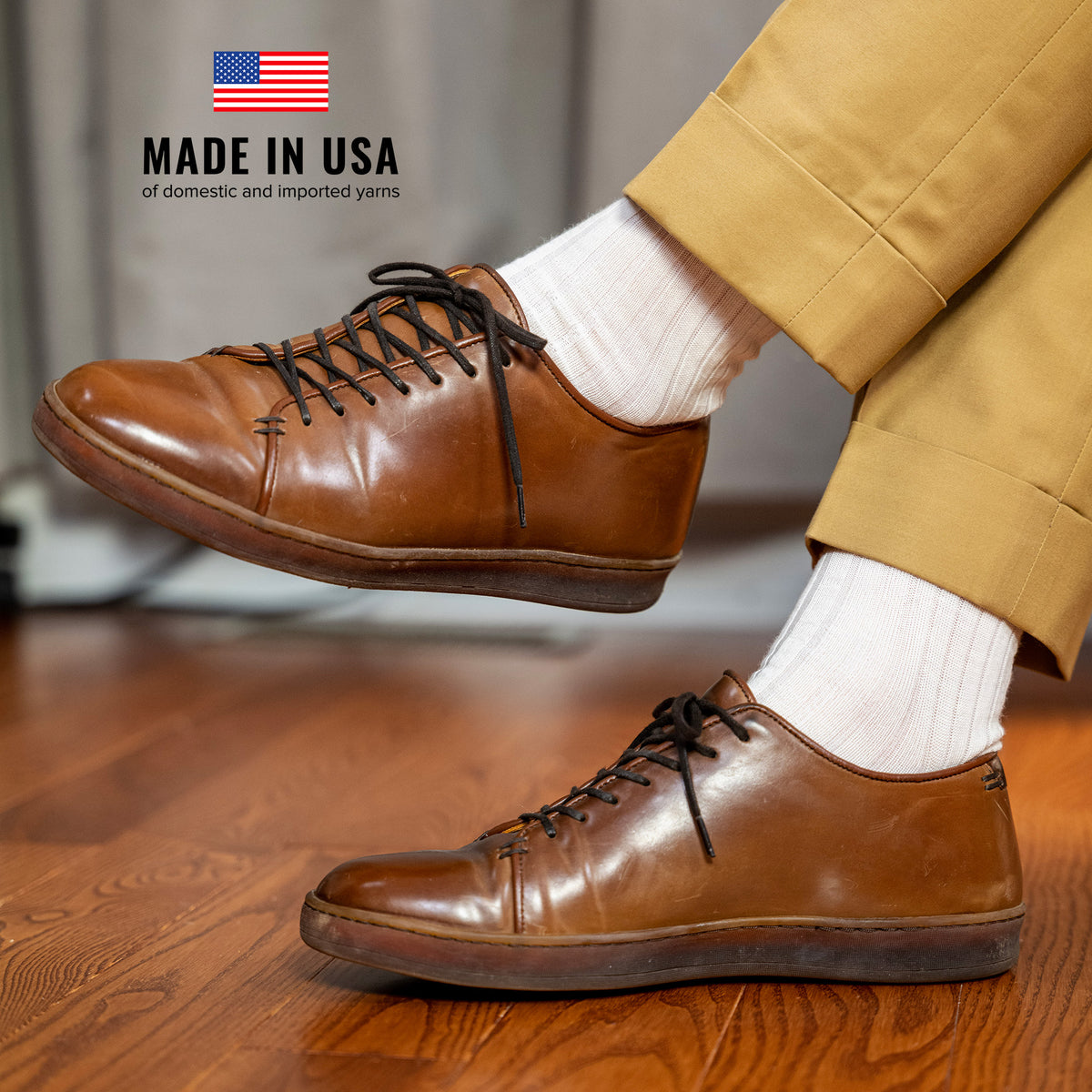 man wearing gold khaki slacks with natural merino wool dress socks and brown leather sneakers