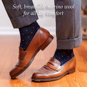 navy dress socks with small orange polka dots being worn by a man walking on a wood floor