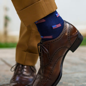 man wearing navy cotton dress socks decorated with small American flags