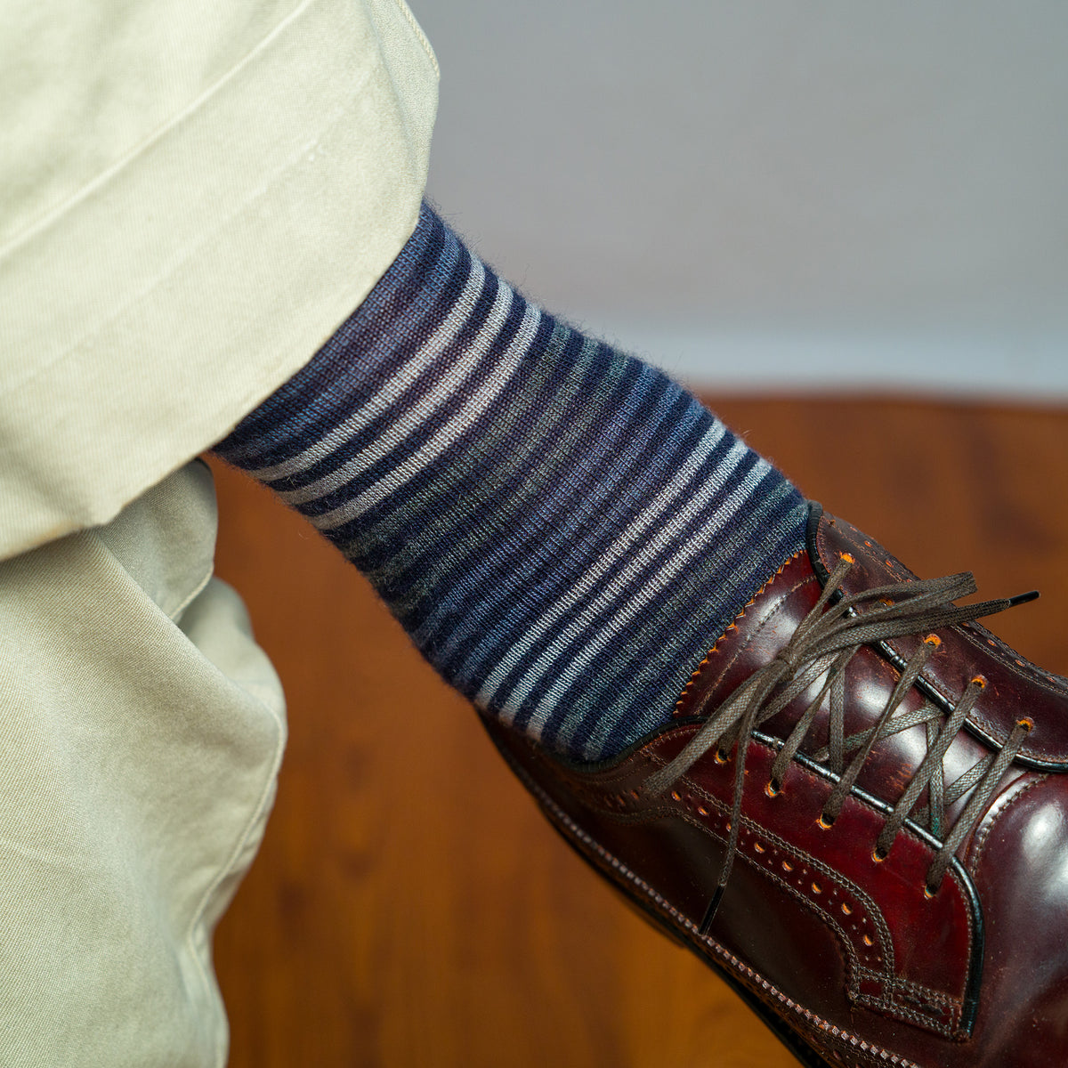 close-up of navy striped dress sock worn with brown wingtip dress shoes and khaki pants