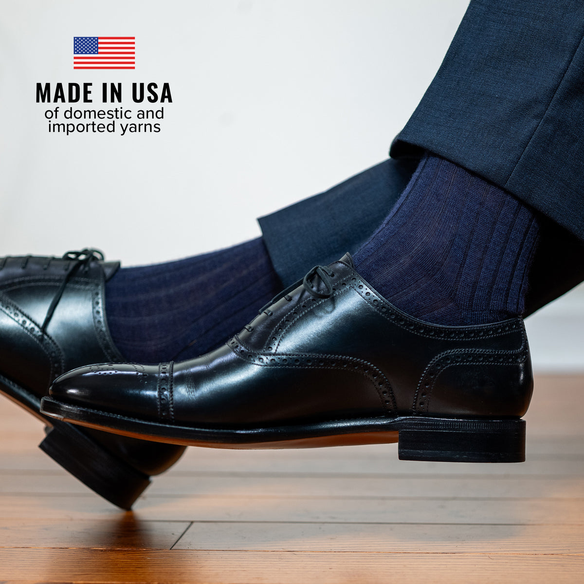 man crossing legs wearing navy wool dress socks with dark slacks and black oxfords