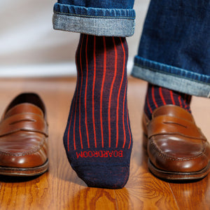 man wearing navy and red shadow stripe dress socks with jeans and brown penny loafers