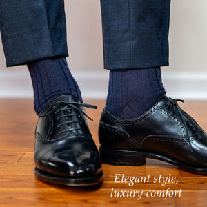 man wearing navy wool dress socks with a navy suit and black oxfords standing on a hardwood floor