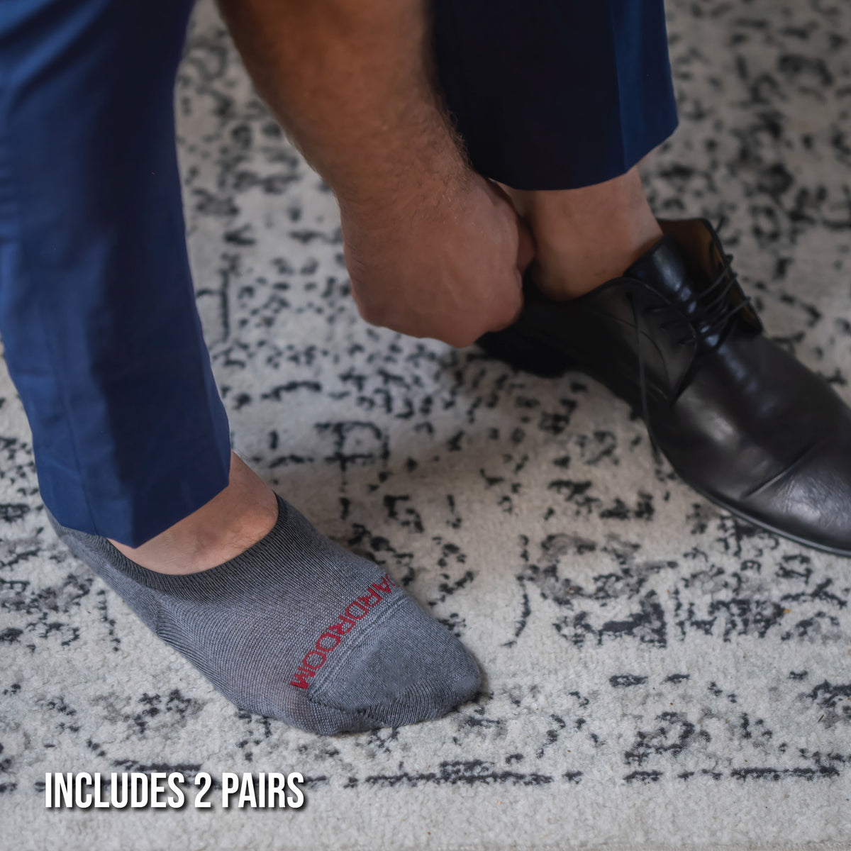 man putting on shoes wearing premium merino wool no-show socks in grey