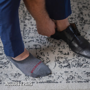 man putting on shoes wearing premium merino wool no-show socks in grey