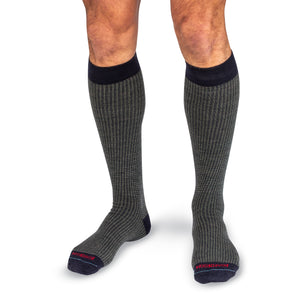 model wearing olive and navy houndstooth over the calf dress socks