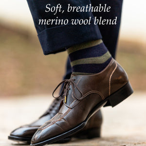 man crossing ankles wearing navy and olive striped dress socks with olive slacks