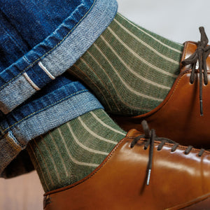 man wearing olive and tan shadow stripe dress socks with jeans and brown leather sneakers