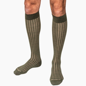 model wearing olive green over the calf shadow stripe socks