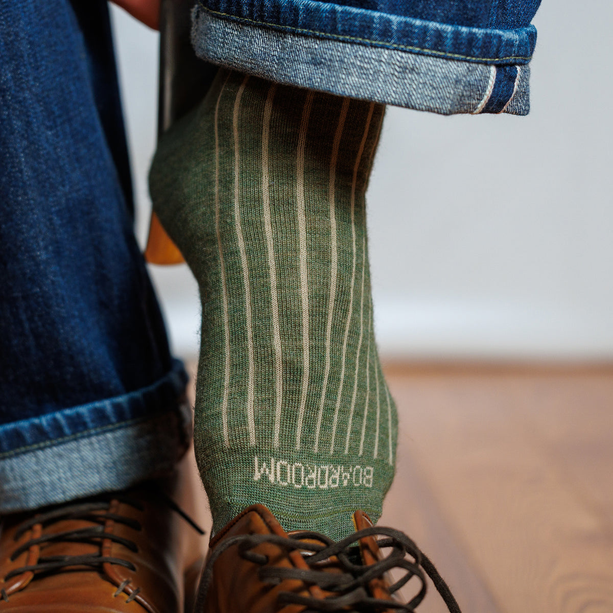 man wearing olive merino wool shadow stripe dress socks with jeans and brown leather sneakers
