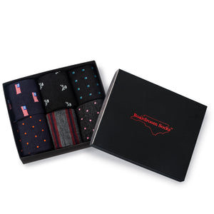 opened gift box filled with six different styles of patterned merino wool over the calf dress socks from Boardroom Socks