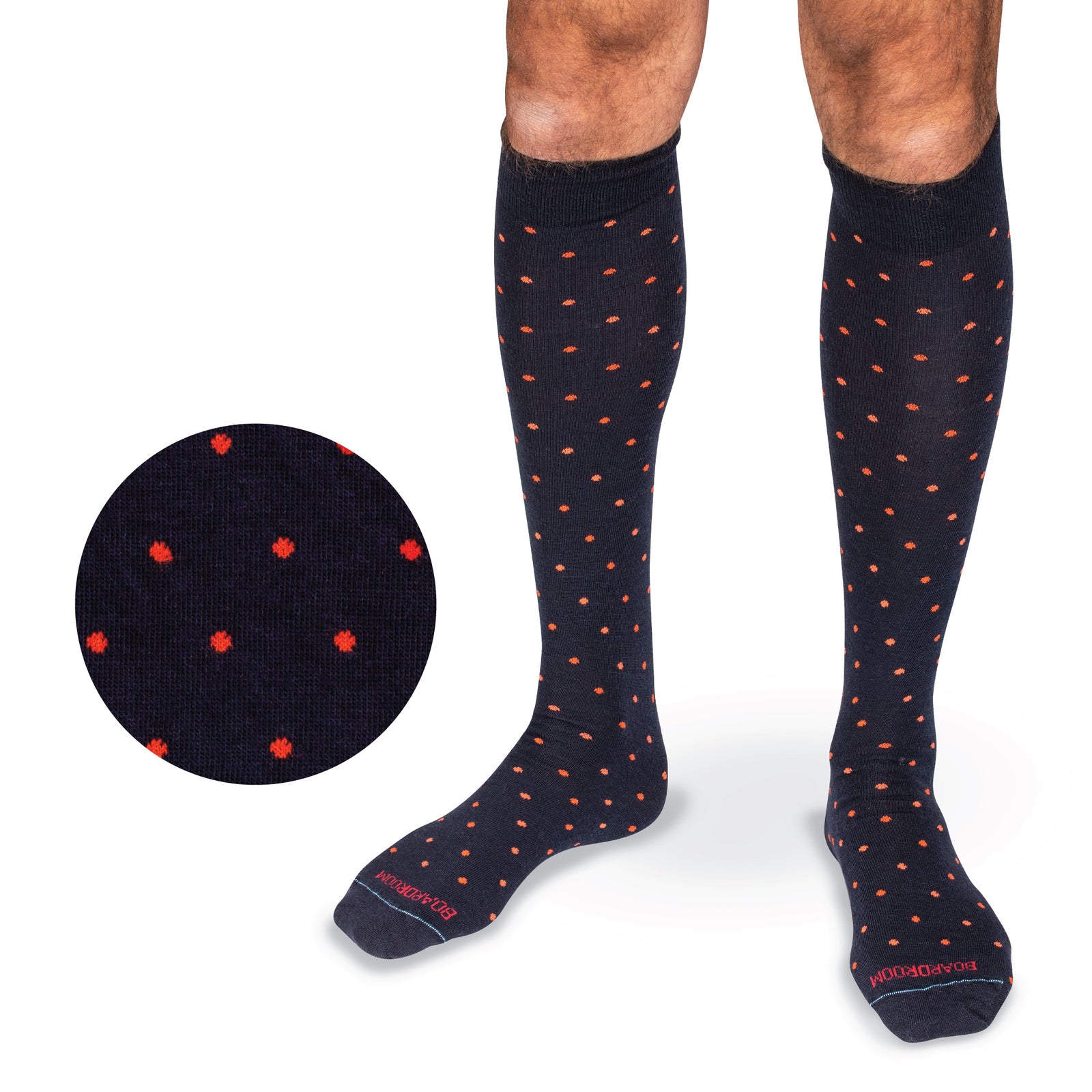 model wearing navy over the calf merino wool dress socks with an orange dot pattern