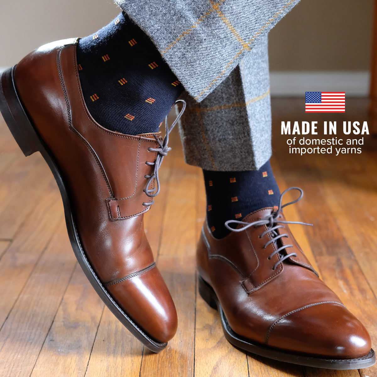 man wearing stylish navy dress socks decorated with small orange geometric pattern