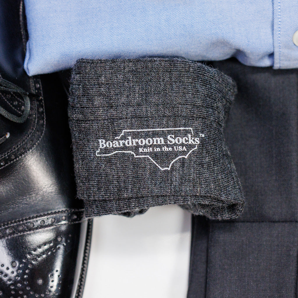 pair of grey heather merino wool dress socks atop a business casual outfit