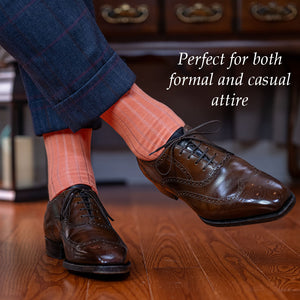 peach colored cotton dress socks with dark brown wingtips and a navy suit