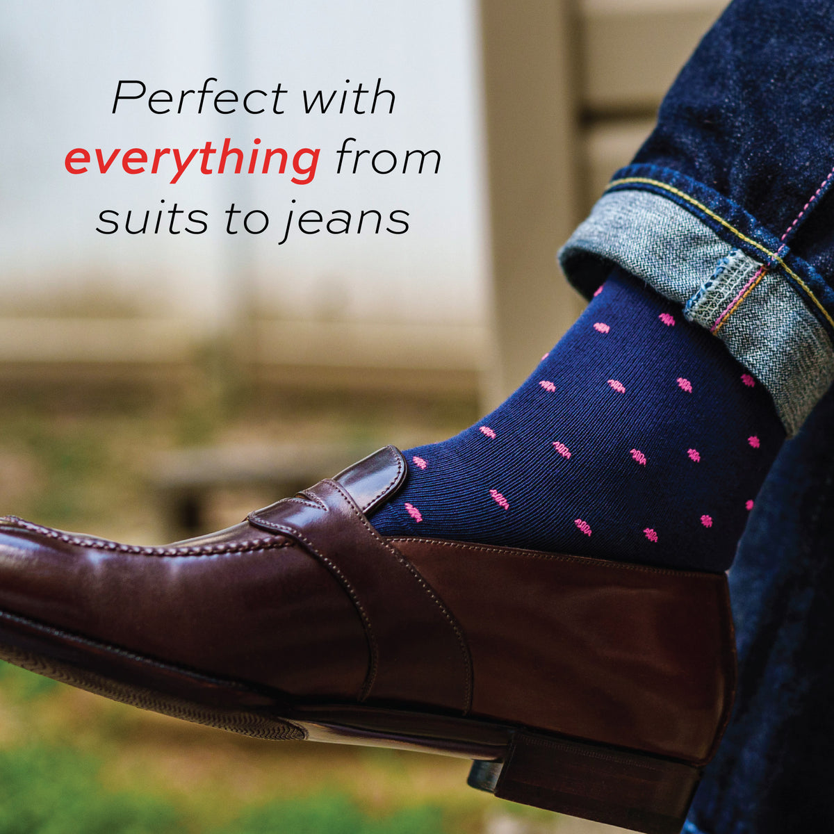 vividly colored close up image of a person wearing navy mid-calf dress socks with bright pink dots