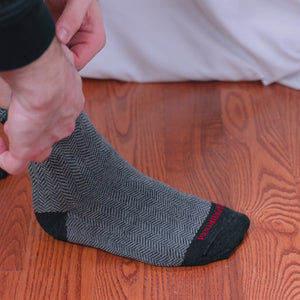 video of man putting on and wearing grey herringbone merino wool dress socks