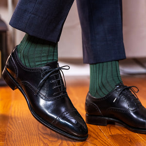 man walking wearing forest green ribbed dress socks with black oxfords and navy trousers