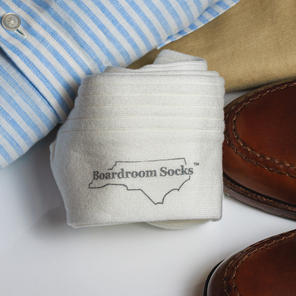 pair of white ribbed cotton dress socks rolled up on top of business casual outfit