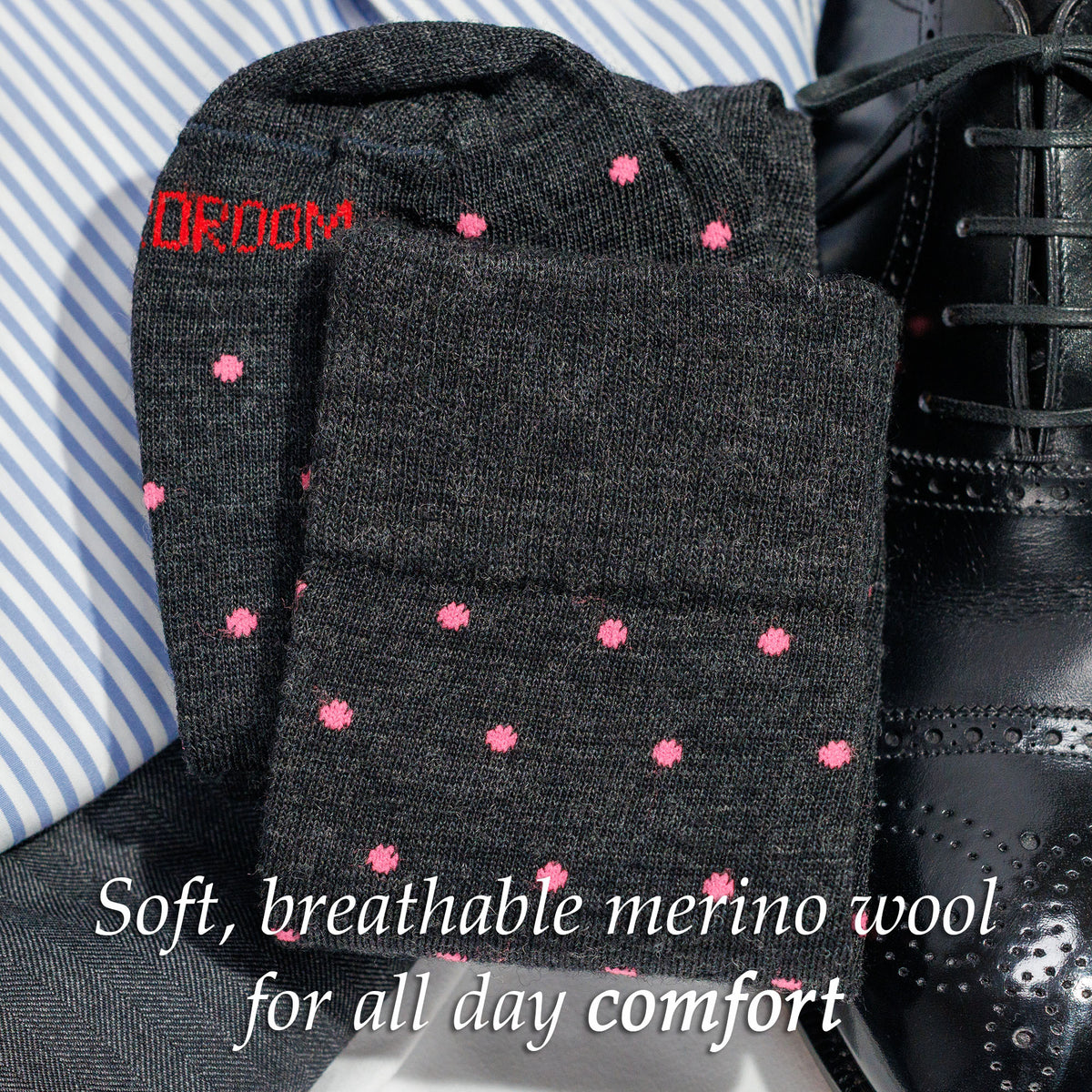 charcoal grey dress socks decorated with pink polka dots sitting atop business casual outfit