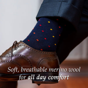 navy merino wool dress socks decorated with alternating orange red and yellow polka dots paired with a charcoal suit and dark brown brogues