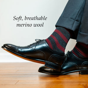 man crossing ankles wearing striped burgundy and dark grey merino wool dress socks