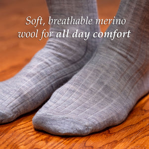 man wearing light grey ribbed merino wool dress socks standing on hardwood floor