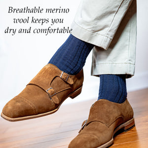 man crossing legs wearing ribbed navy dress socks with khaki pants and brown suede monkstrap shoes