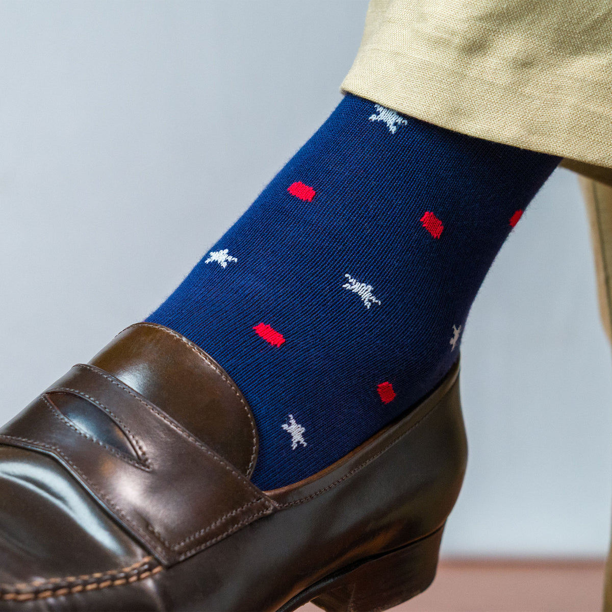 Close up shot of the left foot of a man wearing a cotton star and dot patterned sock