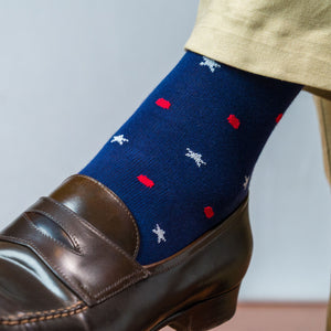 Close up shot of the left foot of a man wearing a cotton star and dot patterned sock