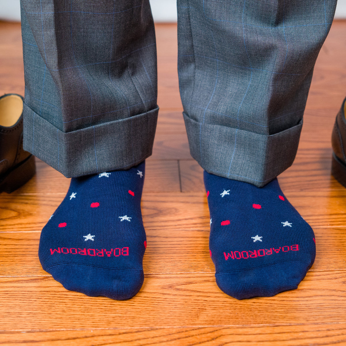 feet standing on hardwood floors wearing cotton star and dot patterned dress socks