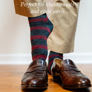 man wearing striped merino wool dress socks sliding on dark brown penny loafers