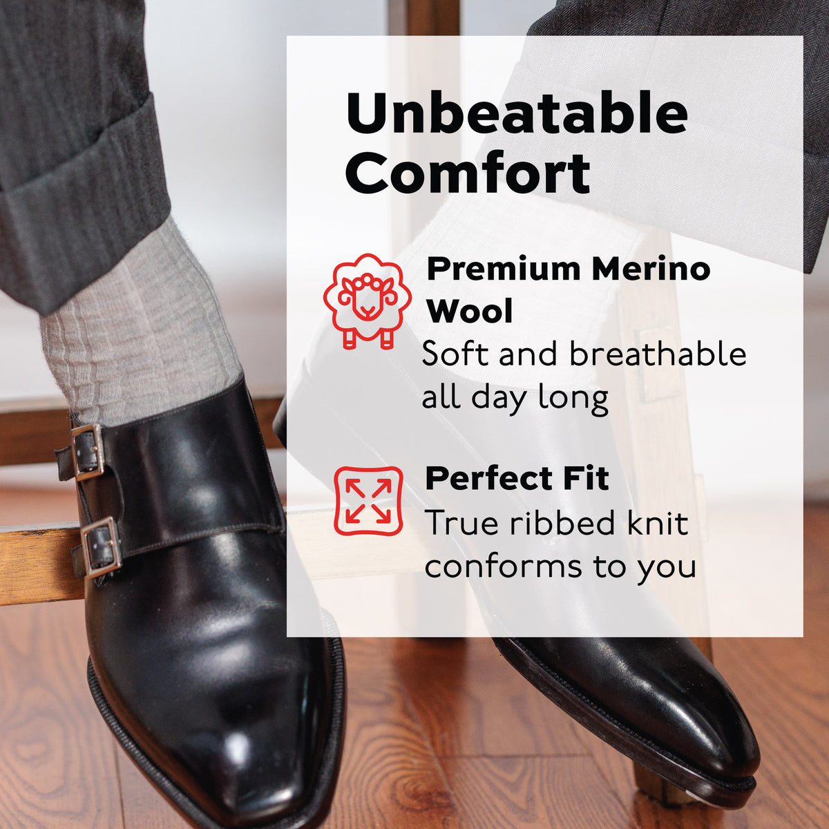 man sitting on stool wearing ight grey merino wool over the calf dress socks and black dress shoes