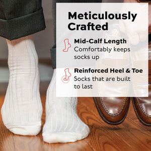 natural merino wool mid-calf dress socks worn on man standing on hardwood floors and holding shoes in his hand